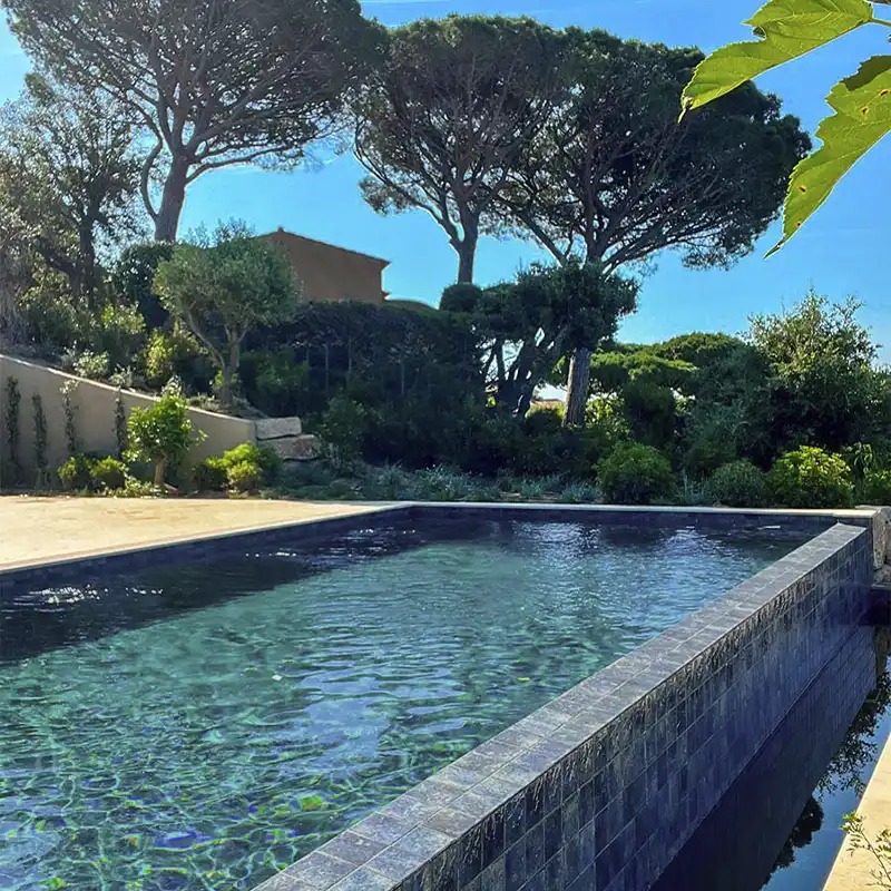 preciosa piscina transbordante revestida com azulejo cor azul