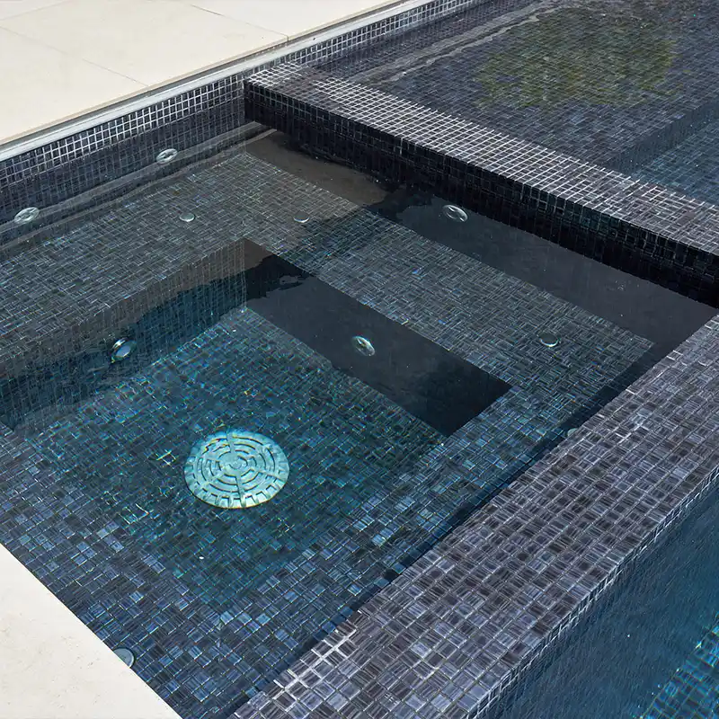 Piscina com pastilha preta que cria um ambiente contemporâneo